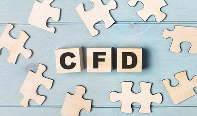 Obraz premium Blank puzzles and wooden cubes with the text CFD Contract for Difference lie on a light blue background.