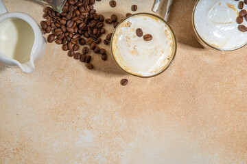 Cold dairy coffee drink with milk, whipped cream. Foamy frappe, latte, cappuccino, on a cream background, space for text. Summer cold coffee cocktail