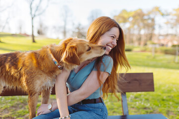 Smiling woman with dog on bench