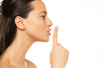 Young  woman with a finger on her lips. silence gesture