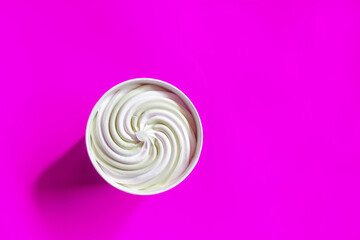 Ice cream in the paper cup on a purple background, top view.soft focus whipped ice cream standing on a paper purple background.Copy space.