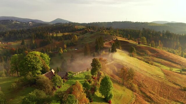 Morning rural landscape with huts on the hills from a bird's eye view. Filmed UHD 4k video.