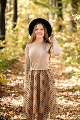 Portrait of a girl in a hat in the autumn forest