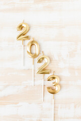 The numbers 2022 in gold color on a wooden table in a vertical arrangement top view. Date of the upcoming New Year and Christmas.