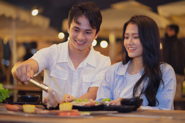 Image of young Asian couple eating dinner together