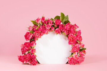 Delicate summer pink spray roses as framing of white round arch on pink abstract scene mockup, copy...