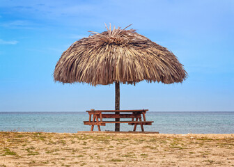 Fototapeta na wymiar Picnic table with sunshade at the Caribbean Sea