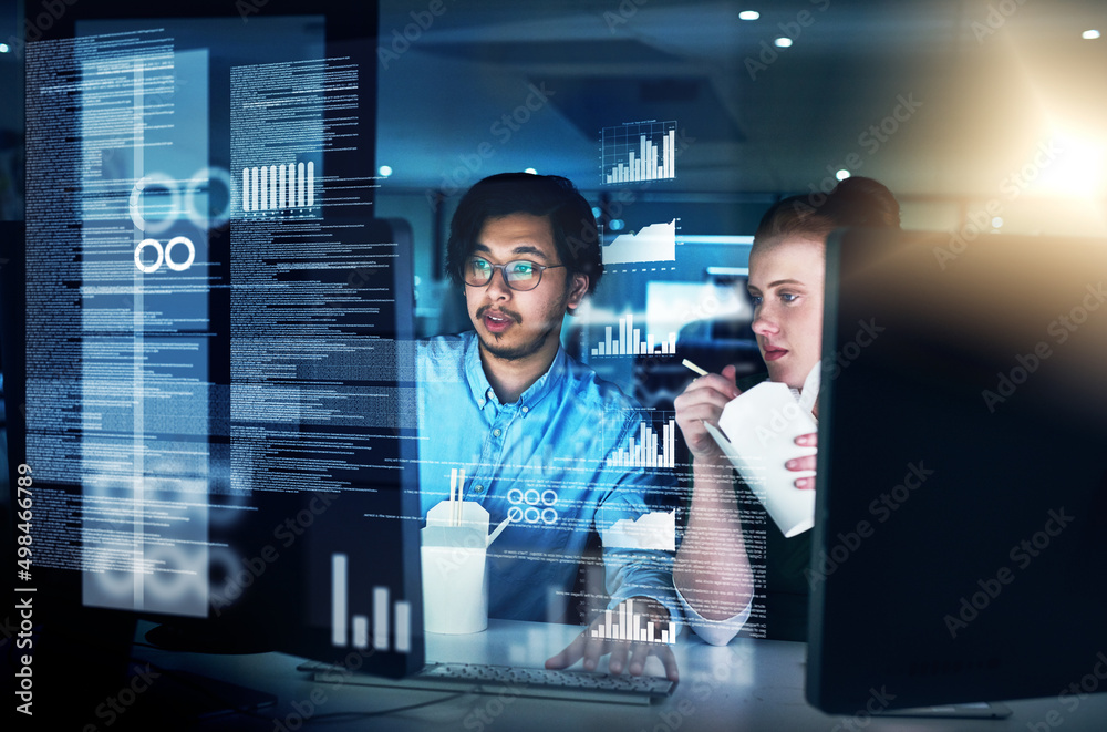 Poster Cracking codes through the night. Shot of two focused young male programmers working together on a computer while eating noodles in the office at night.
