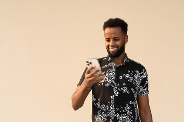 Portrait of handsome young African man using mobile phone