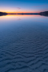 Background image of calm lake with rippled sand in shallow water at dusk, Müritz National Park, Germany