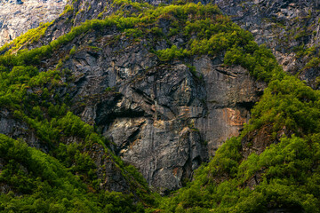Dark stone heart in mountain with green trees background. Aurlandsfjord fjord landscape in Norway Scandinavia