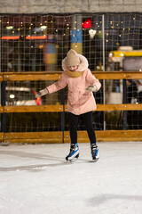 the child was skating on the ice rink - obrazy, fototapety, plakaty