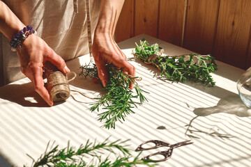 Alternative medicine. Woman holding in her hands a bunch of rosemary. Herbalist woman preparing...