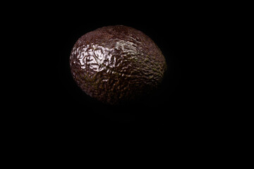 Ripe avocado on a black background. Vegan and vegetarian food