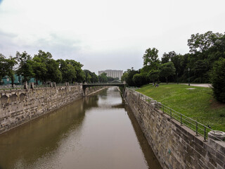 Fototapeta premium Vienna Austria Canal and Foot Bridge with Grass Embankment
