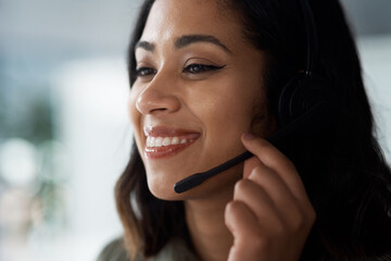 How are you doing today. Shot of a young businesswoman wearing a headset while working in a call centre.