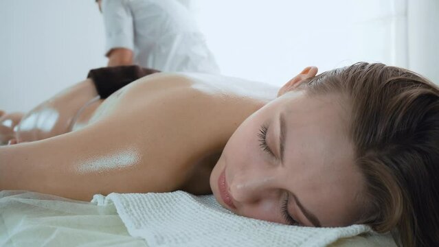 Happy face of young woman at reception for foot massage in spa salon. Concept of body care and alternative medicine