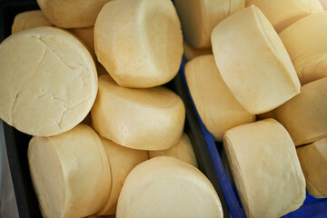 The cheese industry goes round and round. High angle shot of cheese wheels in a factory on a dairy farm.