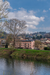 Obraz premium Colored houses facing the river Po, in Torino, Italy. A sky with clouds and green grass.