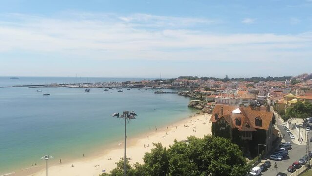 Flying over Duquesa beach at Cascais, with Marina ad Cascais cityscape ,Portugal