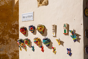 Colourful handicraft pottery on the wall of buildings in Malta, Gozo