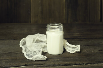 Glass bottle with milk and white napkin.