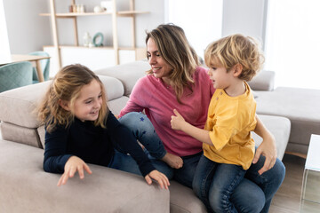 Mother hugging son near daughter