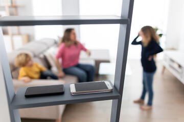 Smartphones on ladder in room with mother with children