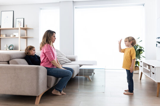 Boy gesticulating while playing with mother and sister