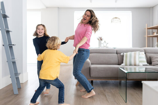 Cheerful Mother With Children Spinning Around