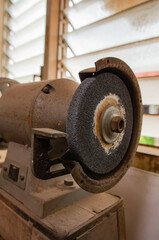 An electric metal grinder that is in the working studio.