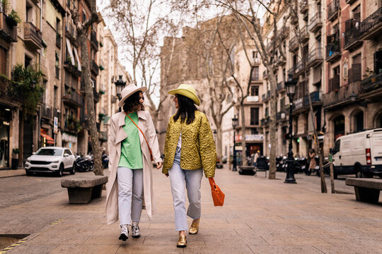 Women in hats walking on street