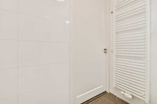 Shower cabin near radiator in bathroom