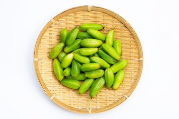 Bilimbi fruit in bamboo basket on white background.
