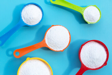 Detergent powder with measuring spoon for clothes washing. Laundry concept.