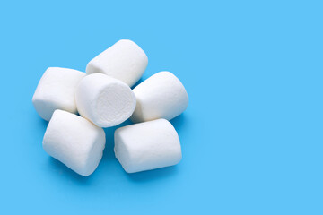 Fototapeta na wymiar Delicious white marshmallows on blue background.