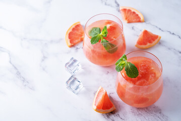 Ruby red grapefruit cocktail with mint leaves in glasses