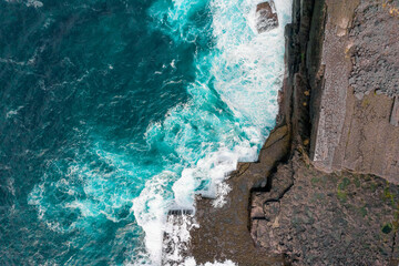 Aerial view on rough stone coast with cliff and blue ocean water. Inishmore, Aran islands, Ireland.