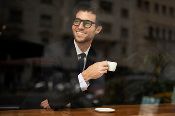 Handsome businessman enjoy in fresh coffee. Young man in suit drinking coffee in cafe.