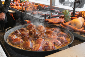 Traditional Polish boneless pork knuckles are boiled in a large frying pan at the Easter Food Festival at the Market Square in Krakow, Poland
