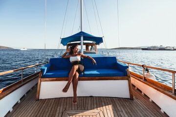 young asian female in a white bikini sitting on a sailboat in the Aegean Sea of Bodrum Turkey...
