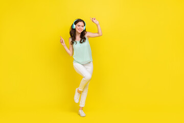 Fototapeta na wymiar Full size photo of overjoyed positive girl enjoy favorite playlist song isolated on yellow color background