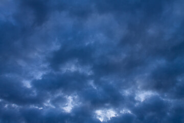 Background texture of dark storm clouds of the sky before a thunderstorm in rainy weather. Baner. Dramatic ominous dark blue clouds.