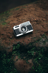 Vintage Silver and Black Film Camera on a Rock Background