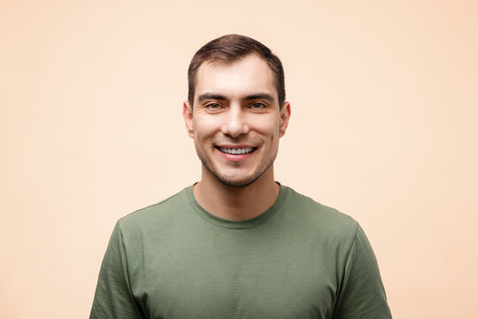 portrait of smiling man in green T-shirt on beige background, mockup