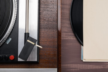 old turntable and vinyl record nearby, top view close-up