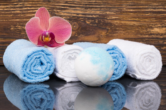 white and blue towels next to bath ball, concept on dark background