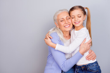 Portrait of two idyllic cheerful relatives cuddle closed eyes isolated on grey color background