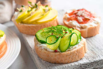 Sandwiches with feta, cucumber, apple and jam on a light background.