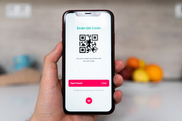 Men's hands using the phone to scan the qr code to pay for delivery. Scan to get discounts or pay for delivery. The concept of using a phone to transfer money or paying money online without cash
